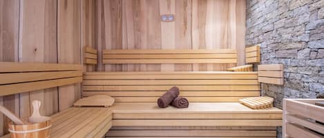 Una sauna con bancos de madera y una pared de piedra.