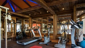 Un gimnasio con cintas de correr, elípticas y pelotas de ejercicio.