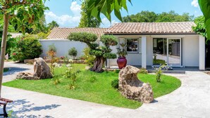 A modern house with a tiled roof, surrounded by a well-maintained garden with rocks and plants. - A Suara by Interhome (Ghisonaccia)