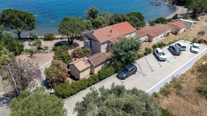 A coastal property with multiple buildings, a parking area, and a view of the sea. - Vacation home Polpu by Interhome (Solenzara)
