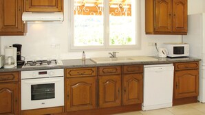 A kitchen with wooden cabinets, a stove, a microwave, and a dishwasher.