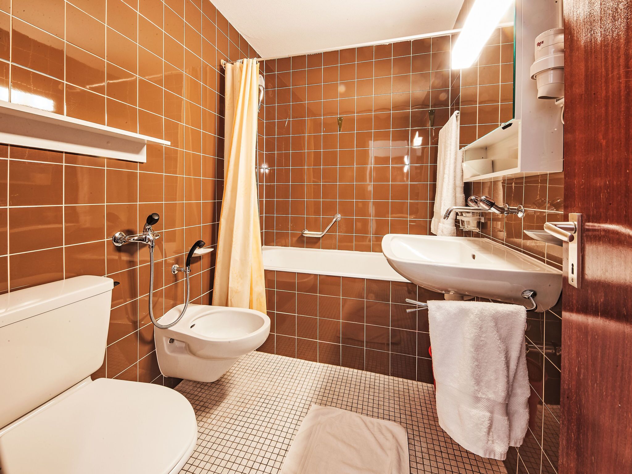 A bathroom with a toilet, bidet, and bathtub.