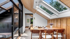 Een modern interieur met een eethoek, houten wanden en dakramen.