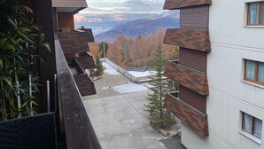 Un bâtiment moderne doté d’un balcon donnant sur un paysage montagneux.