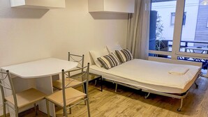 Une petite chambre comprenant un lit, un petit bureau et une chaise.
