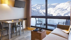 A modern hotel room with a large window offering a mountain view. - Sowell Résidences Pierre Blanche by Interhome (Les Menuires)