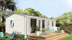 A mobile home with a deck, outdoor seating, and a small garden. - Camping La Plage by Interhome (Argelès sur Mer)