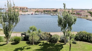 Un port de plaisance où sont amarrés des bateaux, entouré de bâtiments résidentiels et de verdure.
