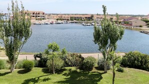 A marina with boats docked, surrounded by residential buildings and greenery. - Catalana by Interhome (Le Barcarès)