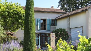 Une maison à deux étages avec un jardin.
