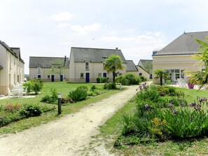 A residential area with multiple houses, a gravel path, and well-maintained gardens.
