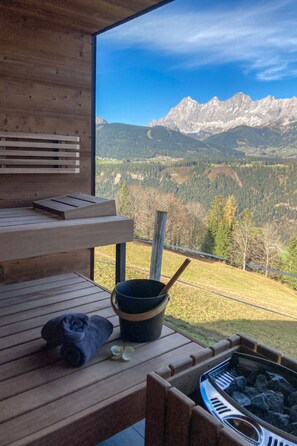 Una terraza de madera con vistas a una cordillera.
