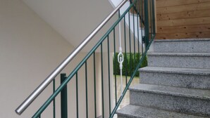 Una escalera con barandillas verdes que lleva a una plataforma.