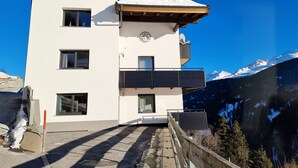 Un bâtiment moderne doté d’un toit plat, de nombreuses fenêtres et d’un balcon.