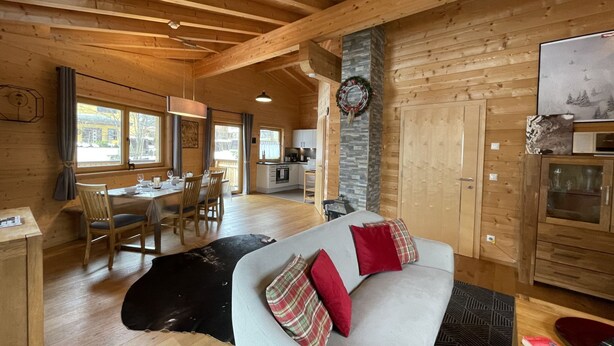 Ein gemütliches Holzhaus-Interieur mit Essbereich, Küche und Wohnzimmer.