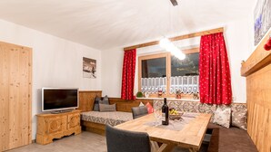 Una habitación acogedora con una mesa de comedor de madera, un sofá y un televisor.