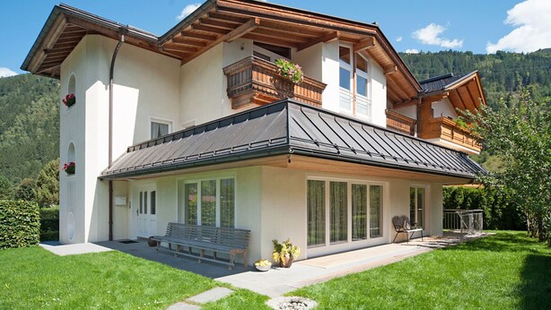 A two-story house with a balcony, large windows, and a well-maintained lawn. - Obetzhofer by Interhome (Zell am Ziller)
