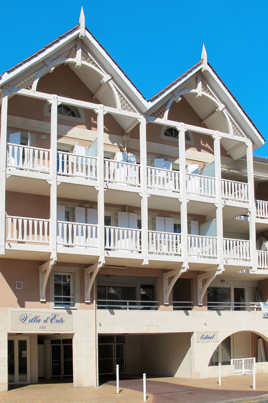 A multi-story hotel with balconies, a sign reading "Villa d'Este," and an entrance labeled "Estival."