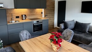 Una cocina moderna con armarios grises, una encimera de madera y un horno empotrado.