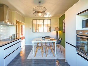 Enjoy cooking in this well-equipped kitchen with a central island, cabinetry, and stainless steel range hood.
