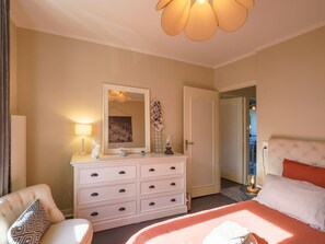 Relax in this inviting space with a large bed, comfortable chair, and convenient dresser.