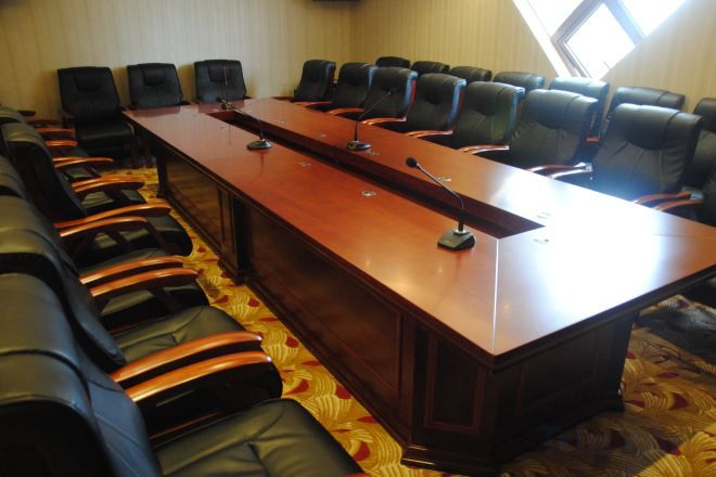 Una sala de conferencias con una larga mesa y varias sillas.