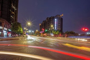 A nighttime city street with illuminated buildings and traffic lights. - Chongqing Yudu Garden Hotel (West Railway Station Baguocheng Branch) (Chongqing)