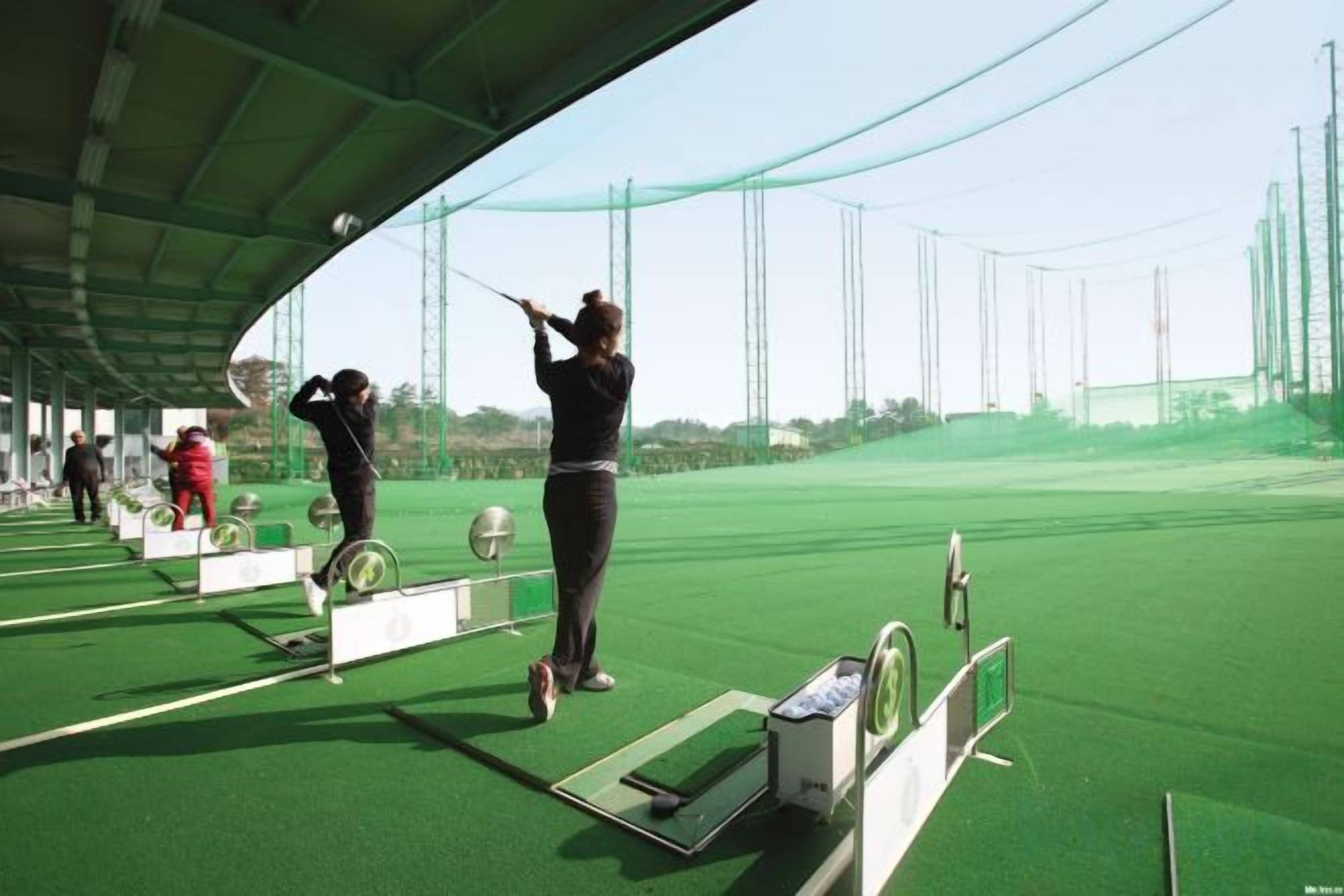 A golf driving range with multiple tee boxes and targets.