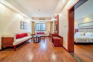 A hotel room with a sofa, a small table, a bed, and a TV. - Chongqing Yudu Garden Hotel (West Railway Station Baguocheng Branch) (Chongqing)