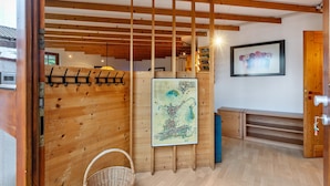 Ein Holzinnenraum mit Holzboden, einer an der Wand befestigten Karte, einem Korbwäscher und einem gerahmten Bild.