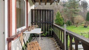 A balcony with a table, chairs, and baskets. - Apartment 'Haus Annenberg' with Shared Terrace, Shared Garden and Wi-Fi (Monzelfeld)