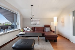 Un salon moderne avec un canapé, une table basse et une fenêtre donnant sur un beau paysage.
