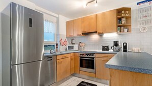 Eine moderne Küche mit Edelstahlgeräten, Holzschränken und einer gefliesten Spritzschutzwand.