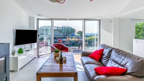 A modern living room with a leather sofa, a wooden coffee table, and a TV on a white cabinet. - La Ganivelle by Interhome (Kerlouan)
