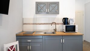 A kitchen with a sink, a microwave, and a coffee maker on the counter. - Studio Apartment 'Appartement 2 - Galopp' with Shared Terrace and Wi-Fi (Ludwigsfelde)