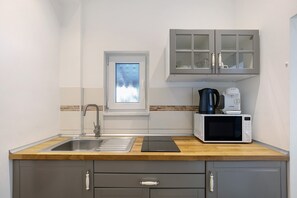 Kühlschrank, Mikrowelle, Herdplatte, Wasserkocher mit Kaffee-/Teezubehör