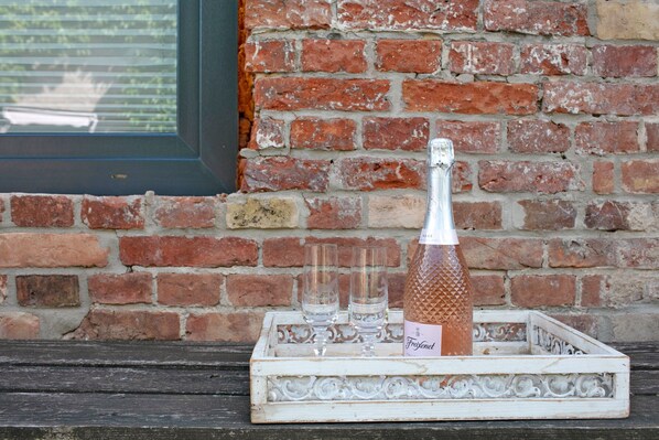 A bottle of Fregonenet champagne on a white tray with two glasses.