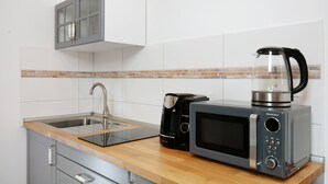 A kitchen with a sink, a coffee maker, a microwave, and a kettle. - Studio Apartment 'Apartment 7 - Nuthefließ' with Shared Terrace and Wi-Fi (Ludwigsfelde)