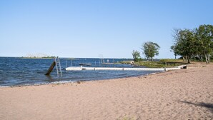A beach with a concrete walkway, a ladder, and a lifeguard stand.