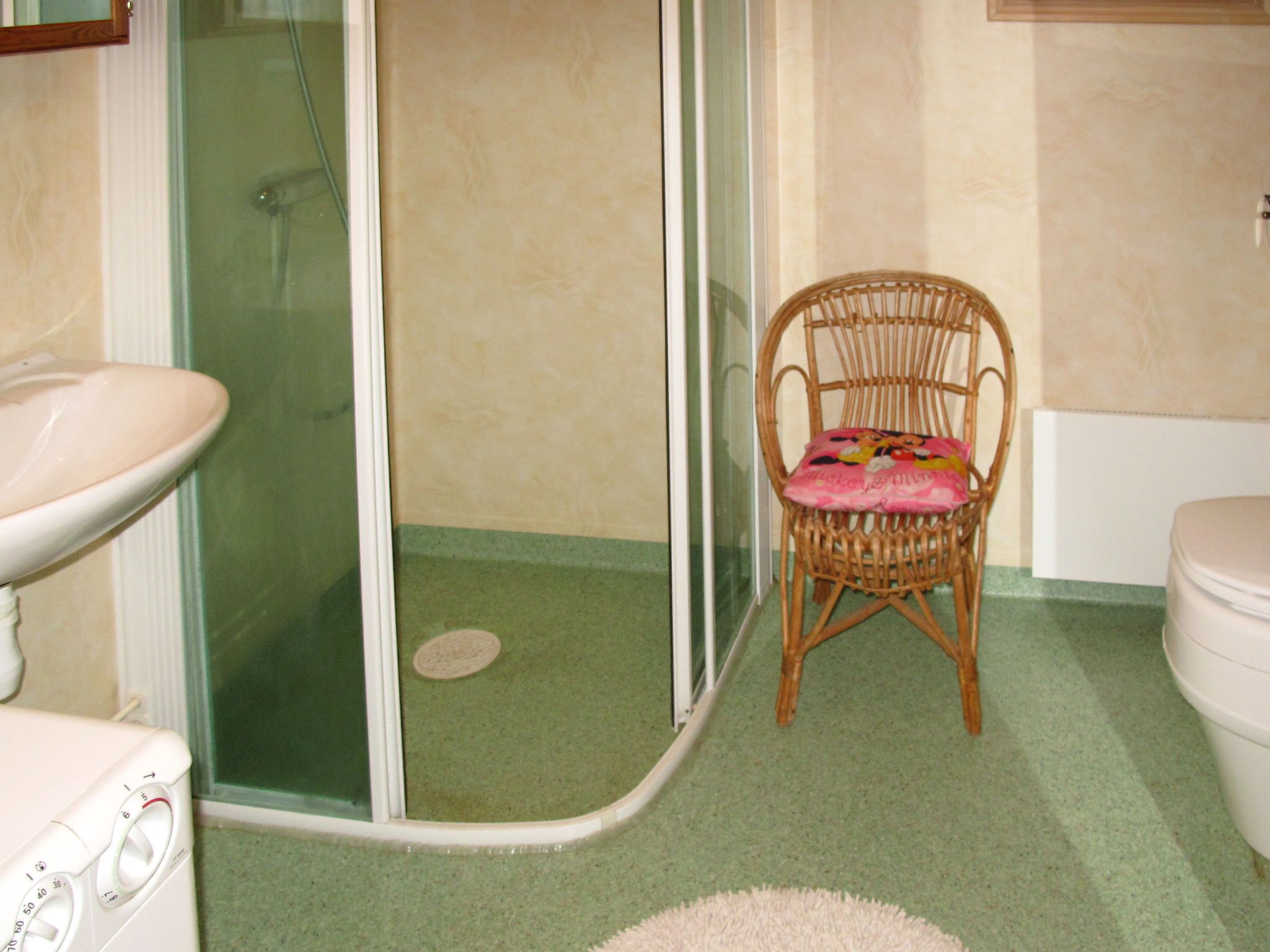 Ein Badezimmer mit Dusche, Waschbecken und Toilette.