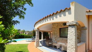 A covered outdoor area with stone pillars, a pool, and outdoor furniture. - Rei Sole (REI315) or San Pietro by Interhome (Costa Rei)