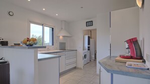 A modern kitchen with a central island, a built-in oven, and a coffee machine. - Golf de Bretagne by Interhome (Sarzeau)