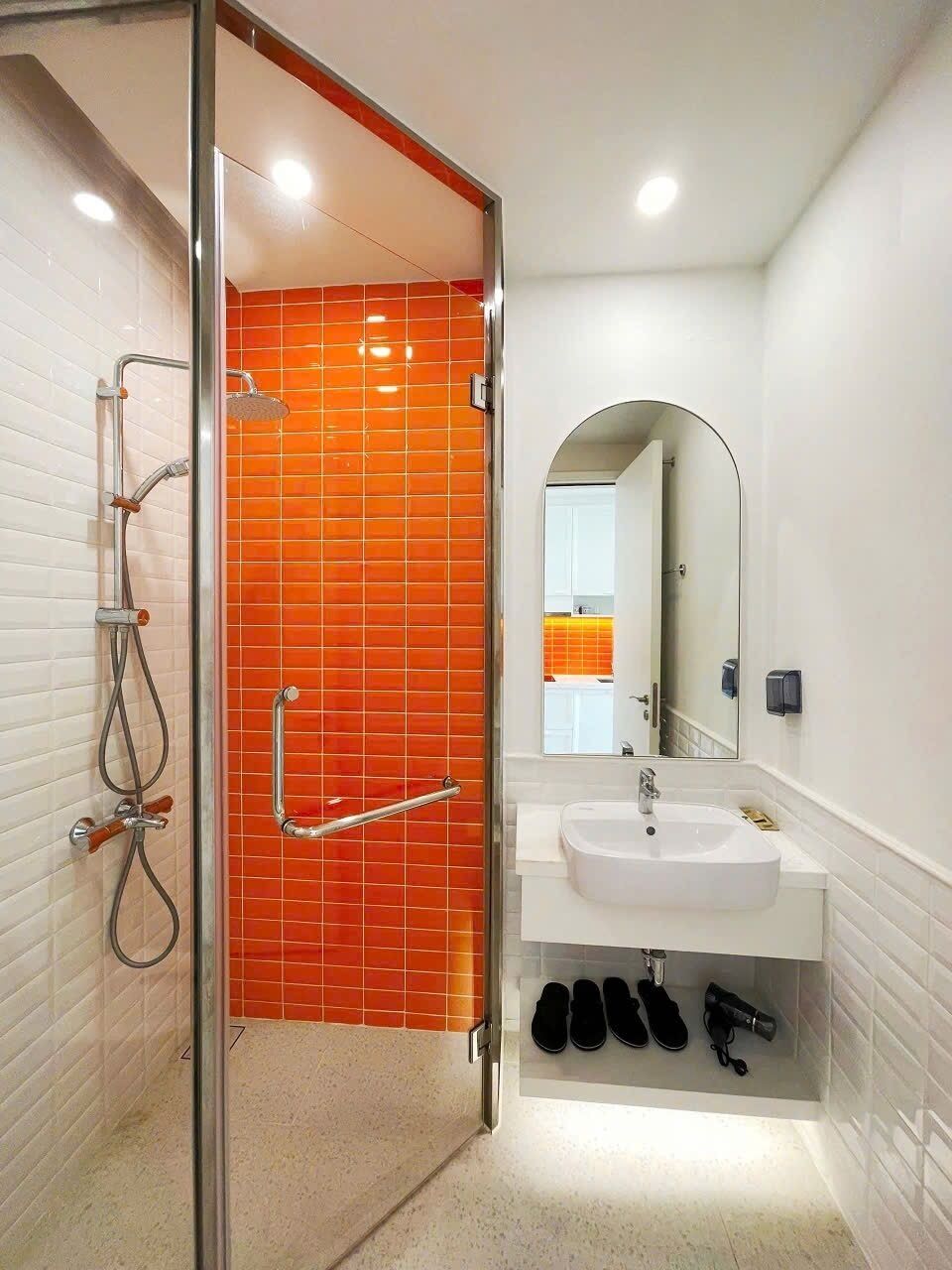 A bathroom with a shower, a sink, and a mirror.