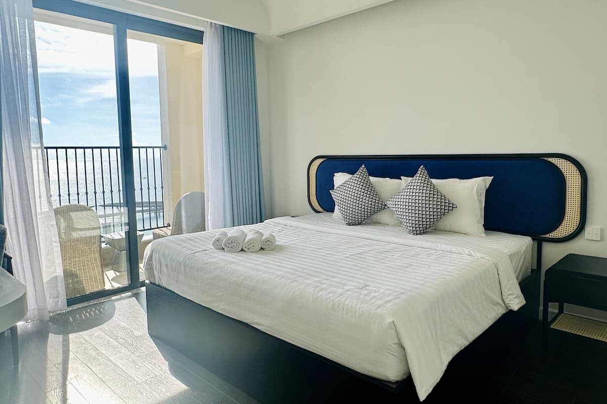 Une chambre d’hôtel dotée d’un grand lit, d’un balcon avec vue et d’un design moderne.