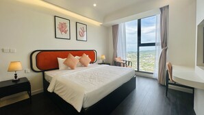 Een moderne hotelkamer met een groot bed, een nachtkastje met lamp, een stoel en een groot raam met uitzicht op de stad.