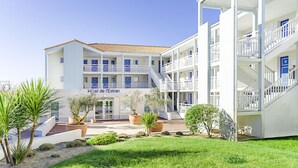 Un hotel con recepción, varios balcones y cielo despejado.
