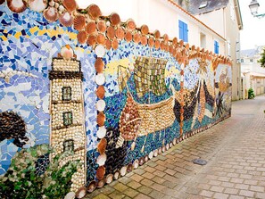 A mosaic wall with a maritime theme, including a ship and sea shells. - L'Estran (25M) by Interhome (Chateau d'Olonne)