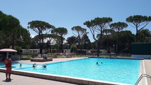 A swimming pool surrounded by trees and buildings. - Campeggio del Forte by Interhome (Marina di Bibbona)