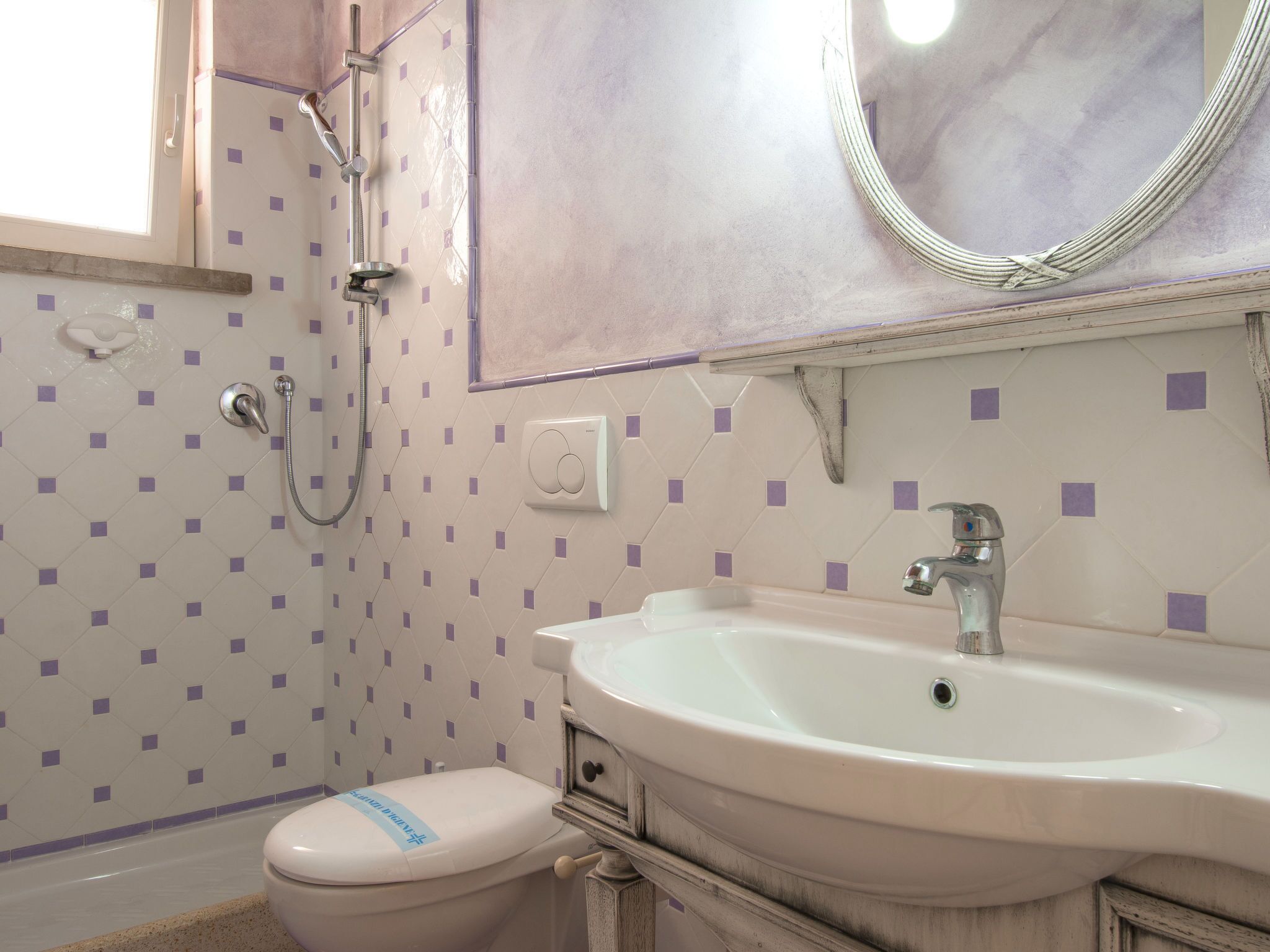 Une salle de bain avec des toilettes, un lavabo et une douche.