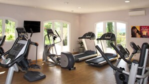 Una palestra con tapis roulant, ellittica e cyclette.